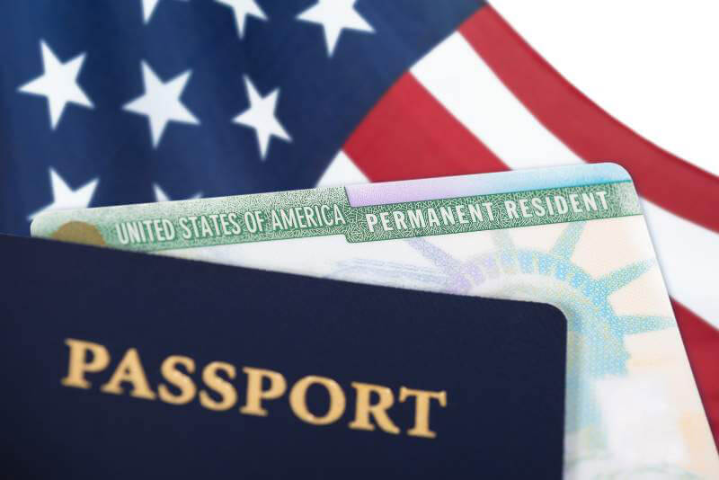 green card passport and american flag green card passport and american flag